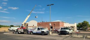 air excellence trucks and team at work with a crane installing a new ac unit for a business image